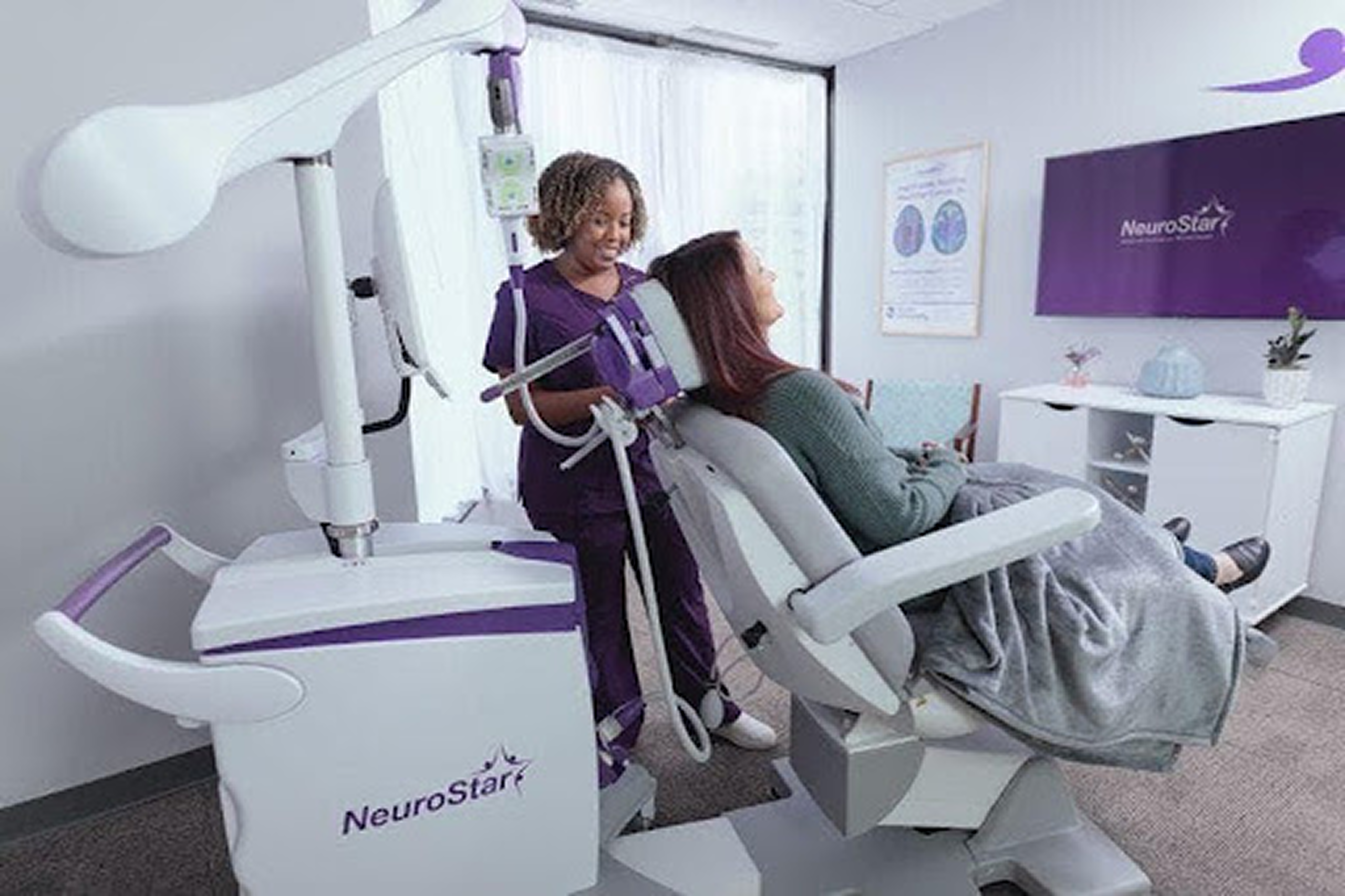 What is TMS FDA cleared diagnosis? A nurse positions a NeuroStar TMS device over a reclined patient during treatment.